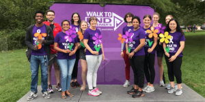 The AANCL and the HFA Lab staff members posing in front of the Walk to End Alzheimer's banner